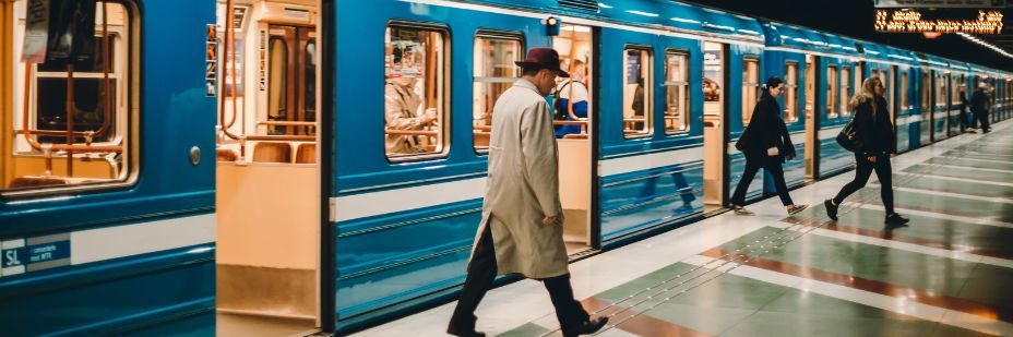 Un homme sortant des transports en communs, il marche sur le quai du métro.